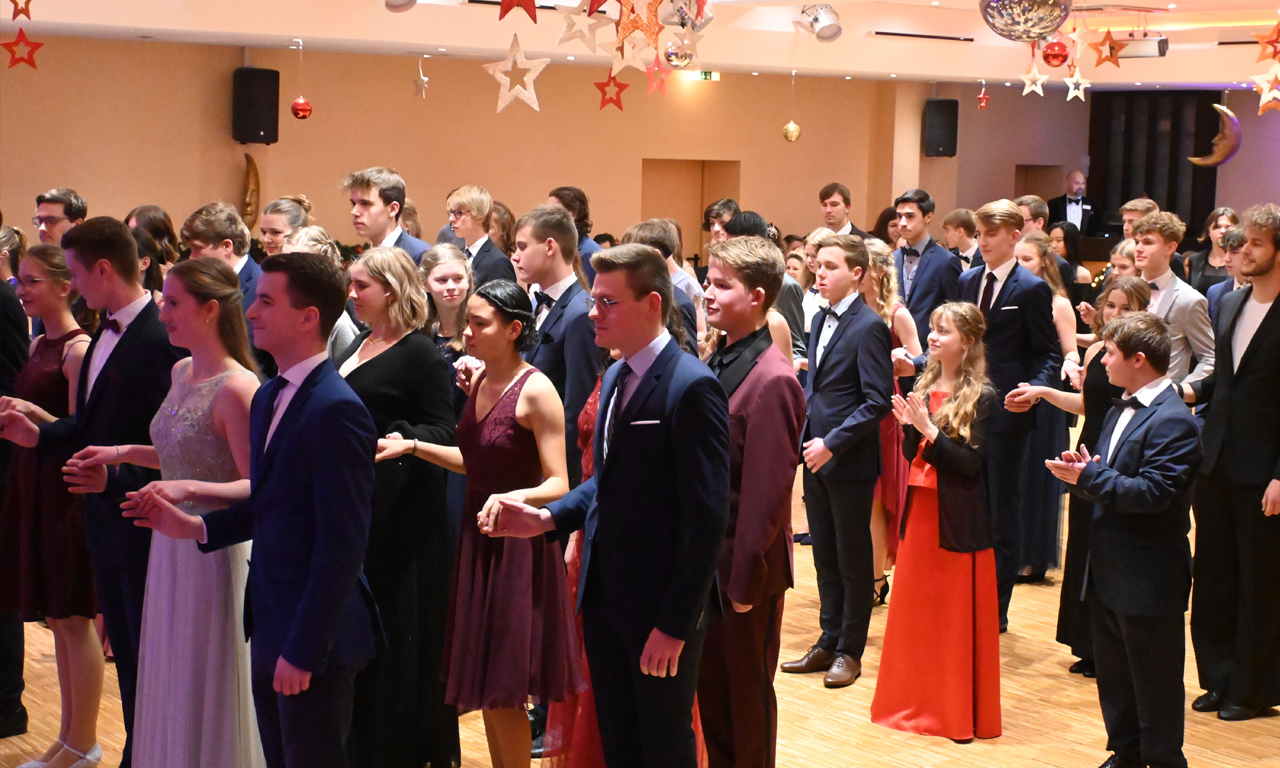 Viele Leute stehen schick gekleidet auf der Tanzfläche der Tanzschule Stüwe-Weissenberg