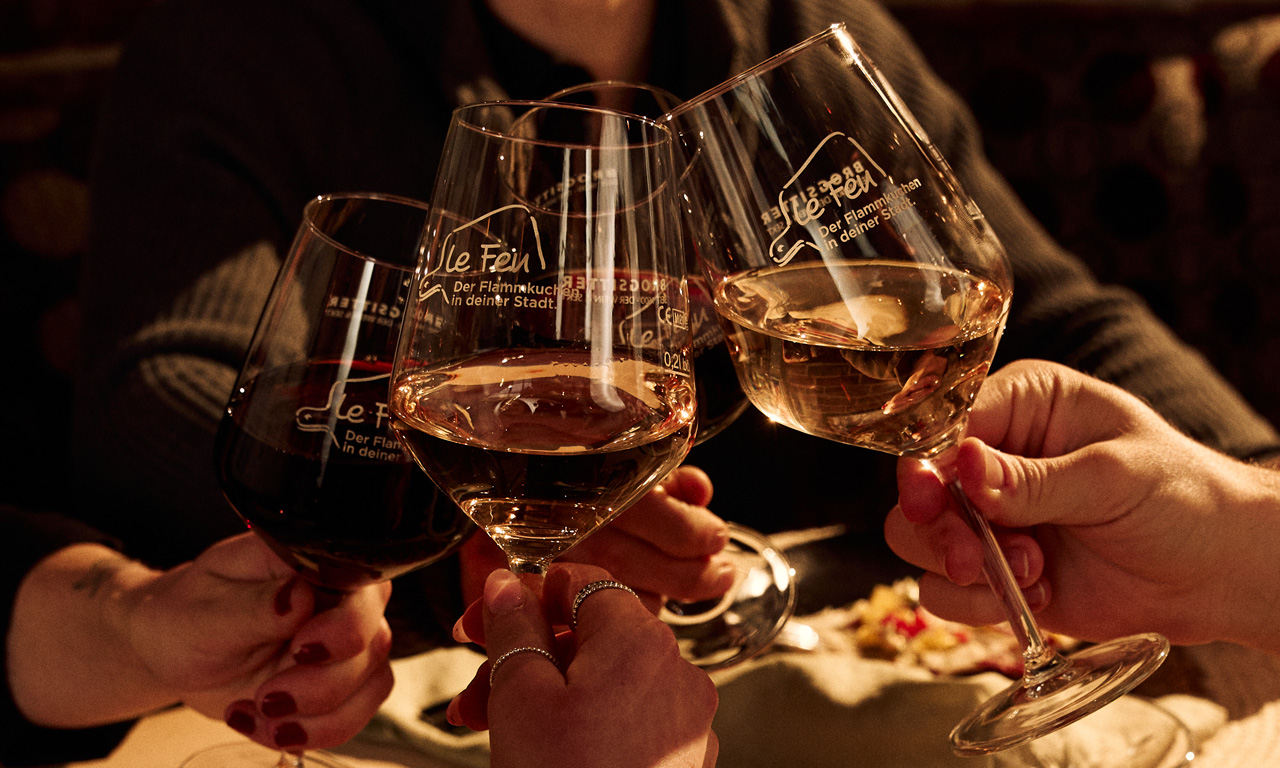 Le Feu - Vier Personen stoßen mit Wein an